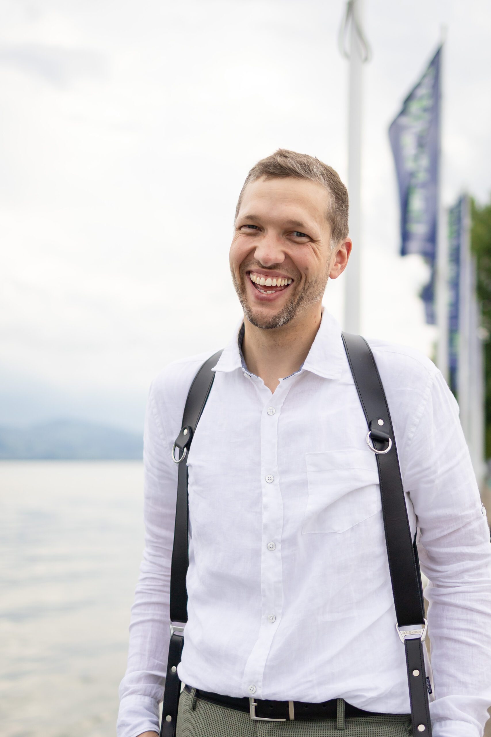 Karl-Peter Nägele in die Kamera lachend mit Kameragurt am Bodensee